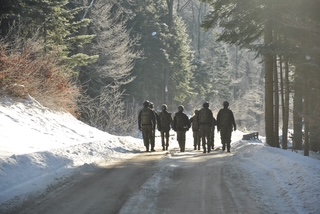 Uczniowie maszerują na ośnieżonej drodze
